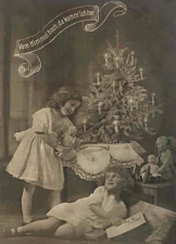The classic German Christmas tree, as shown in this early 1900s postcard, was a small fir or spruce, set on a table, with relatively sparse decorations and lit candles. Don't try this at home. Click for a larger photo.